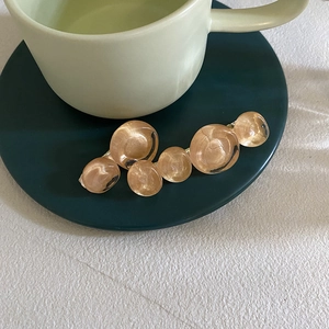 Detail view of vintage amber resin bubble hair clip with gold metal base on elegant tableware