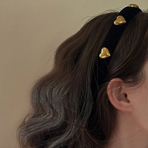Retro black velvet headband with gold heart accents shown on model in side view profile