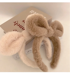 Detail of plush rabbit ear headbands in cream and brown on aesthetic book props