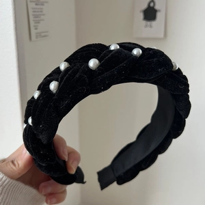 Detail of black velvet braided headband featuring elegant white faux pearls on thick fabric