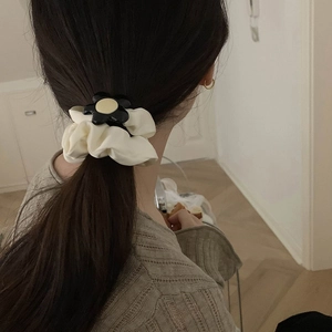Elegant cream ruffled scrunchie with black and yellow floral charm for hair styling