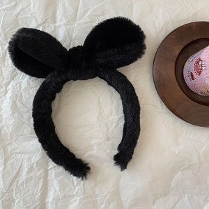 Close-up of soft black plush headband with cute bunny ears and fuzzy fabric texture