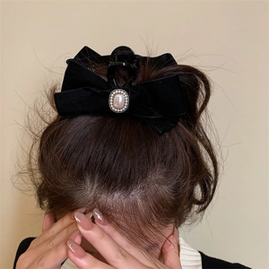 Grande pince à cheveux élégante en velours noir avec nœud et perle sur cheveux bruns