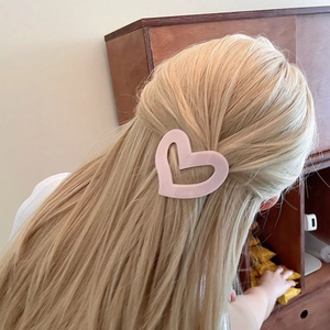 Matte pink hollow heart hair clip styled on blonde hair for a sweet minimalist look