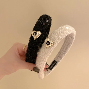 Dettaglio della trama in tweed con paillettes e bottone a cuore dorato sul cerchietto