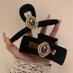 Detail of velvet hair claw clips with gold rose relief and pearls in vintage style