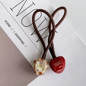 Vue détaillée de deux élastiques à cheveux avec pendentifs tulipes rouges et ambre