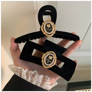 Detail of vintage black velvet hair claws with gold rose relief and white pearls