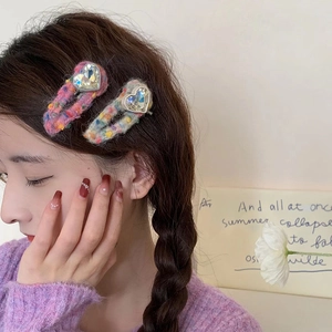 Détail de barrettes coeur en strass enveloppées de laine tricotée sur un modèle