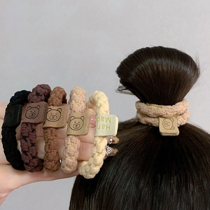Five knit hair ties in earth tones featuring leather bear tags and high elasticity