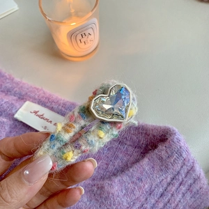 Détail d'une barrette à cheveux cœur en cristal sur base pelucheuse pour un style automnal