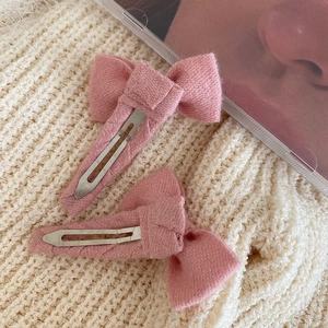 Lot de deux barrettes nœuds en tissu rose avec clips BB argentés sur tricot blanc