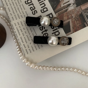 Elegant close-up of black velvet hair clips with faux pearls and rhinestones