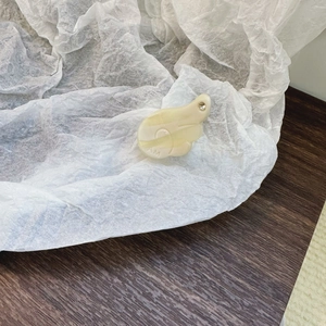 Dettaglio macro della molletta per capelli crema con incisione AM e piccolo strass