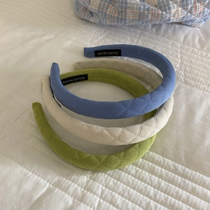 Padded plaid fabric headbands in blue, beige, and green with a diamond knit texture