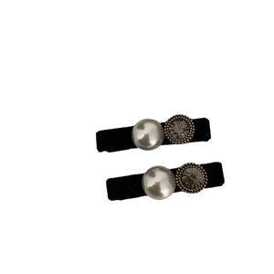 Elegant black velvet hair clips with lustrous pearls and gray faceted crystals on white background