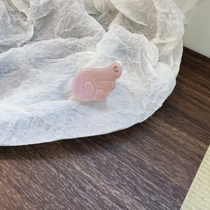 Dettaglio della mini pinza per capelli rosa ad ala in acetato con incisione AM
