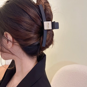 Grande molletta per capelli nera opaca con logo in metallo dorato per uno stile elegante