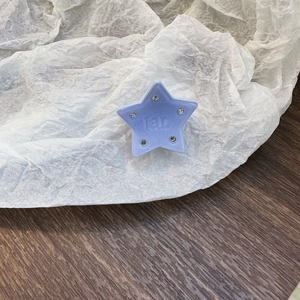 Dettaglio del fermaglio per capelli a stella in acetato viola chiaro con strass lucidi