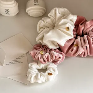 Premium velvet hair scrunchies in white and pink with gold logo charms for women