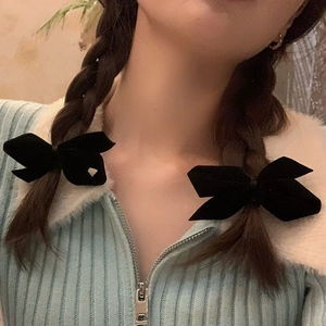 Elegant pair of black velvet bow hair clips on braided hair for a stylish sweet look