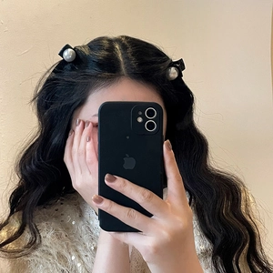 Detail of French vintage pearl hair clips on model showcasing glossy black material and pearls