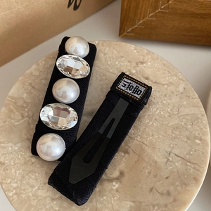 Elegant French vintage hair clips with white pearls and crystals on black twill fabric