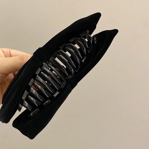 Detailed view of a large black velvet bow hair claw clip with smooth inner grip texture