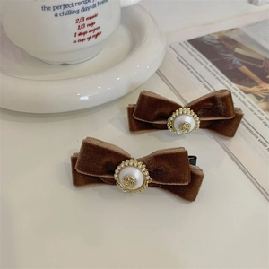 Vintage fluwelen strik haarspelden met parels en gouden details in een set