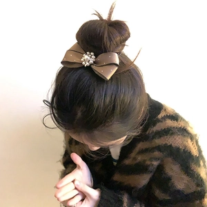 Elegant dark brown satin bow hair clip with faux pearl and rhinestone center on bun hair