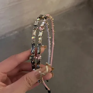 Close-up of thin gold metal headbands with pink and gray rhinestones and crystals