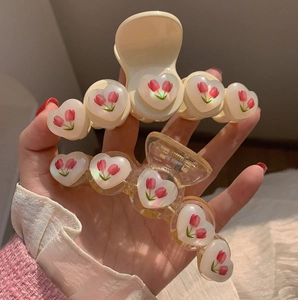 Dettaglio delle mollette a cuore con delicati motivi di tulipani rosa in due colori