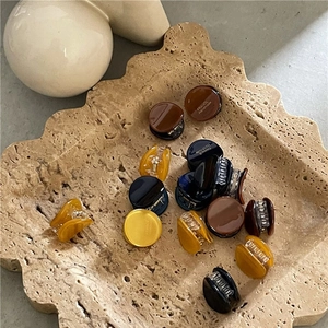 Mini pinces à cheveux en acrylique marron et ambre sur un plateau en pierre décoratif