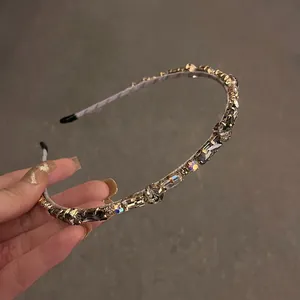 Close-up of hand-held metal headband with sparkling grey and clear inlaid crystals