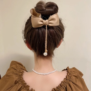 Elegant champagne satin bow hair claw with gold tassel and pearl detail for high ponytail