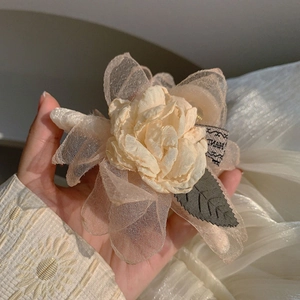 Detailansicht der champagnerfarbenen Organza-Kamelien Haarklammer mit handgefertigtem Band