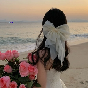 Détail d'un nœud en organza blanc pour mariée avec un élégant voile en résille de plage