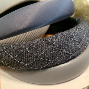 Close-up detail of dark blue satin and black quilted sponge headband fabric textures