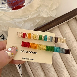 Close-up of rainbow rectangular bead hair clips set with clear crystal texture