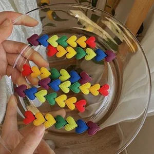 Rainbow heart hair clip set for girls made of colorful leather on a clear glass bowl