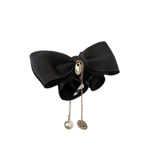 Elegant black bow hair claw clip with gold chains and pearl accent on white background