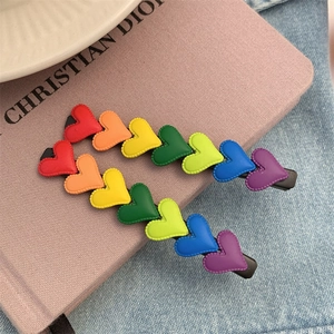 Rainbow heart hair clips set with seven colorful matte hearts on a black base for women