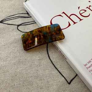 Detail view of handmade tortoiseshell acetate barrette with golden France lettering