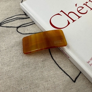 Detailed macro of tortoiseshell resin hair clip with gold France Handmade lettering