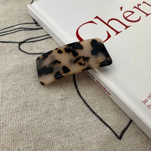 Detailed close-up of tortoise shell pattern hair clip with gold France handmade text