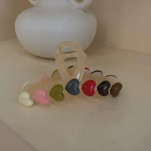 Detail of a large translucent hair claw clip with colorful heart-shaped ornaments