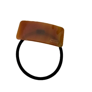 Brown tortoise shell acetate hair tie with gold lettering and high elastic black rope