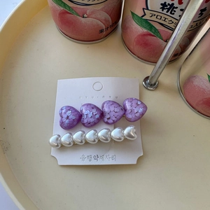 Detail of sweet purple sequin heart hairpin and white pearl hair clip set on display card