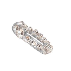 Barrette vintage argentée avec zircons étincelants de forme ovale sur fond blanc