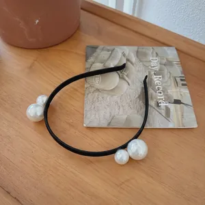 French vintage style slim black headband featuring four glossy white oversized pearls